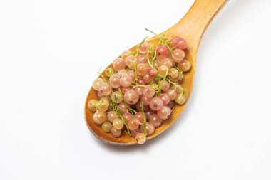 Beyaz arka planda ahşap kaşıkta üzümlü üzümler. Bir sürü olgun, beyaz frenk üzümü. Lezzetli meyve.