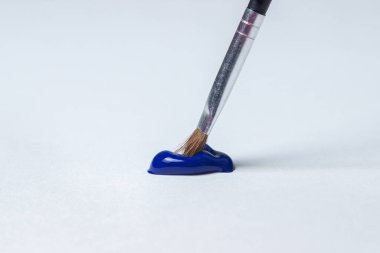 Beyaz arka planda mavi boyayla boyamak için fırça. Suluboya boya