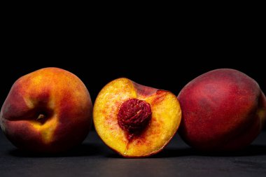 Siyah arka planda şeftaliler. Şeftali kesimi. Sağlıklı beslenme.