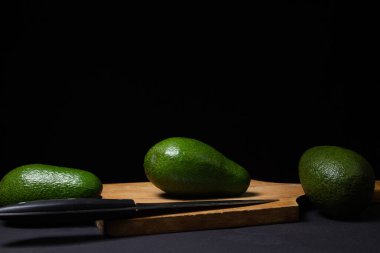 Siyah arka planda avokado. Koyu arkaplanda yeşil avokado