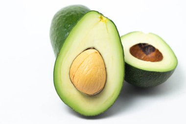 Beyaz arka planda avokado. Avokado ikiye bölündü