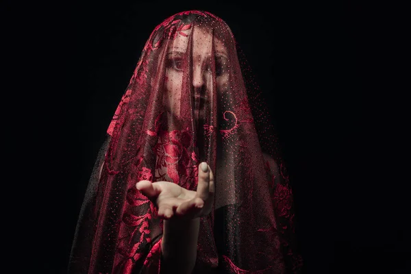 Kızın yüzü siyah bir arka planda kırmızı bir peçe ile kaplıdır. Koyu renk bir kız resmi