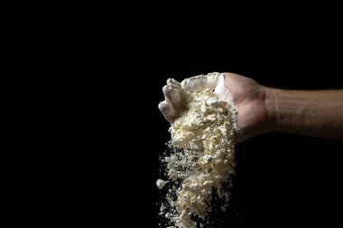 Un siyah arka planda elden dökülüyor. Koyu arkaplanda en yüksek kalitede un.