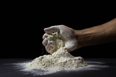 El, siyah arkaplandaki un yığınından un alır. Koyu arkaplanda en yüksek kalitede un.