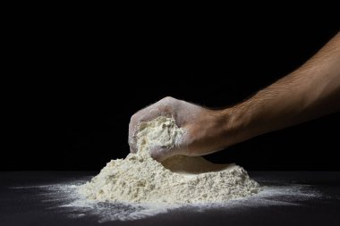 El, siyah arkaplandaki un yığınından un alır. Koyu arkaplanda en yüksek kalitede un.