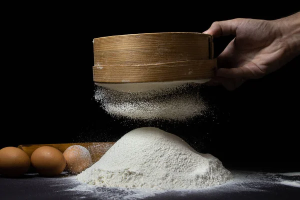 Un, siyah bir arka planda elekten geçirilir. Koyu arkaplanda en yüksek kalitede un.