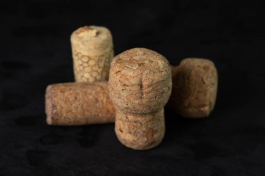 Karanlık bir arka planda şarap ve şampanya mantarları.