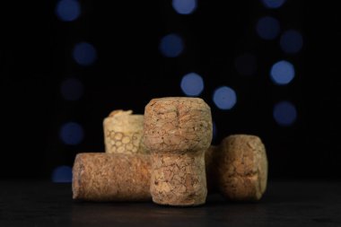 Karanlık bir arka planda şarap ve şampanya mantarları.