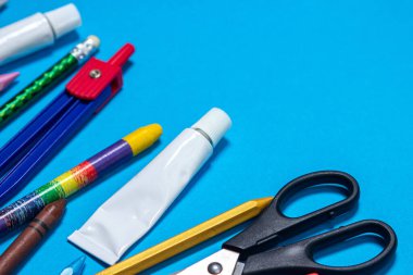 Fotokopi alanı olan mavi arka planda okul malzemeleri. Okul konseptine dönelim.