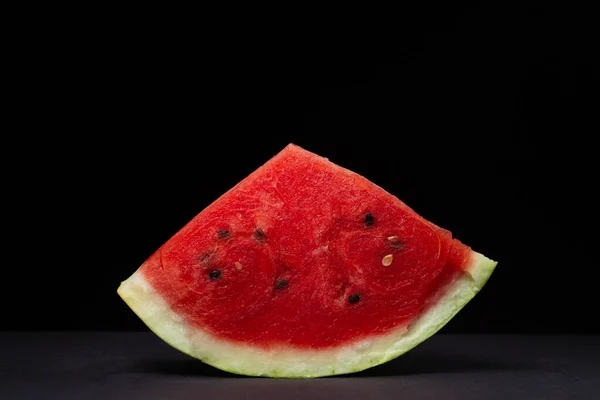 Watermelon on a black background. Isolated slice of watermelon