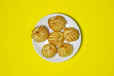 Sarı arka planda hafif bir tatlı. Beyaz tabakta şekerleme.