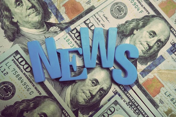 News concept. Blue letters on a background of US dollars