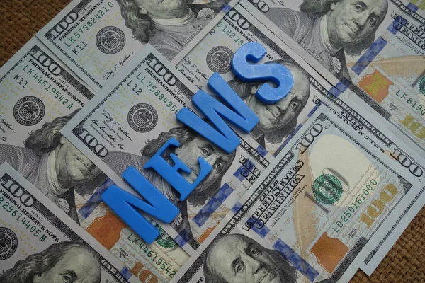 News concept. Blue letters on a background of US dollars