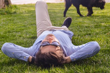 Çim zemin üzerinde işadamı uzan