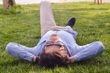 Çim zemin üzerinde işadamı uzan