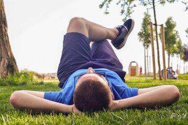 Genç adam yalan aşağı çim zemin üzerine