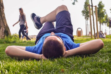 Genç adam yalan aşağı çim zemin üzerine