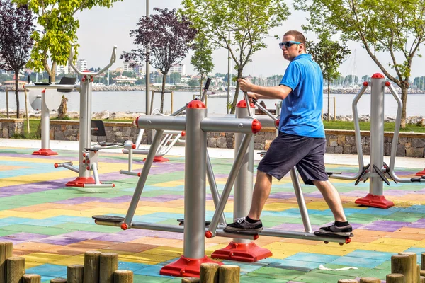 Man working out on working equipment outdoors — Stock Photo, Image