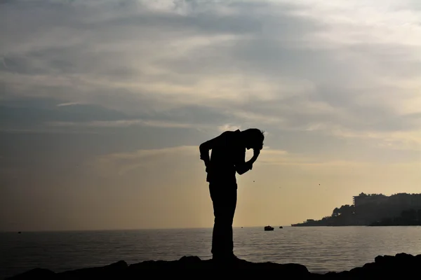 Чоловік на морському фоні силует: Реймс і смуток — стокове фото