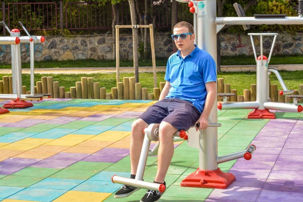 Man working out on working equipment outdoors — Stock Photo, Image