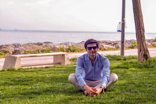 Podnikatel, sedět na zemi trávy — Stock fotografie