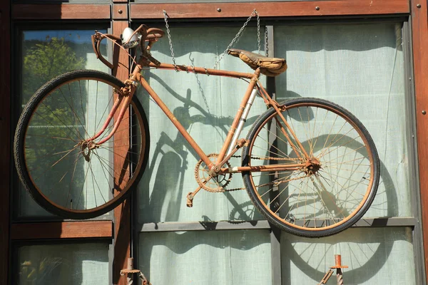 Bicycle hanging on window — Stock Photo, Image