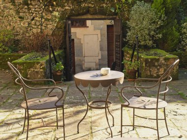 Santillana del Mar, İspanya - 28 Aralık 2019 - Santillana del Mar kentindeki tarihi-sanatsal değere sahip ulusal turizm salonunun terasında masa ve sandalyeler