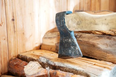 Yakacak odun yığınına saplanmış ahşap saplı eski bir balta.