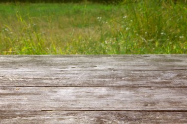 Yeşil çimenlerin bulanık arka planında ahşap desenli gri tahtalardan yapılmış sokak tahtası.