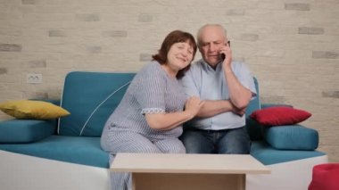 Adam telefonda oğluyla konuşuyor ve karısı da tartışmayı dinlemeye çalışıyor..