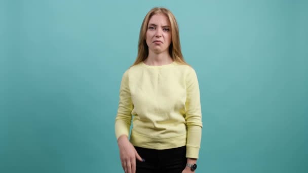 Jonge verveelde vrouw bla bla gebaar met de hand, geïsoleerd op turquoise achtergrond. — Stockvideo