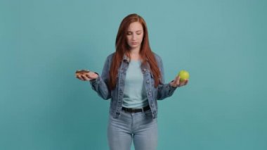 Elma ve donut arasında seçim yapan genç bir kadın..