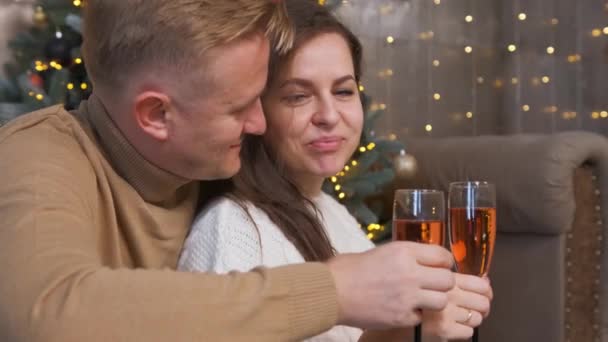 Couple amoureux assis et câlin près du sapin de Noël et boire du champagne. — Video