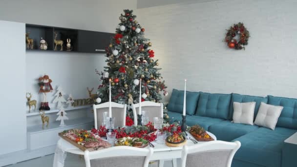 美しく配置されたリビングルームでおいしい料理でいっぱいのクリスマステーブル. — ストック動画