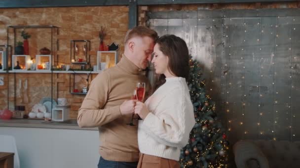 Υπέροχο ζευγάρι χορεύει κοντά στο χριστουγεννιάτικο δέντρο και πίνει σαμπάνια. — Αρχείο Βίντεο