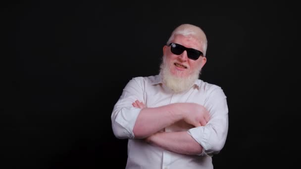 Крупним планом бородатий чоловік з альбінізмом, який посміхається на чорному тлі . — стокове відео