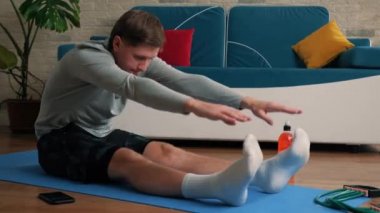 Genç adam evde egzersiz yapıyor..