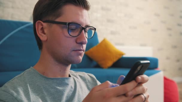 Close-up van een man schrijf een bericht met behulp van een mobiele telefoon, thuis geïsoleerd blijven. — Stockvideo