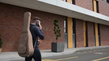 Genç sanatçı dışarıda konser menajeriyle telefonda konuşuyor..