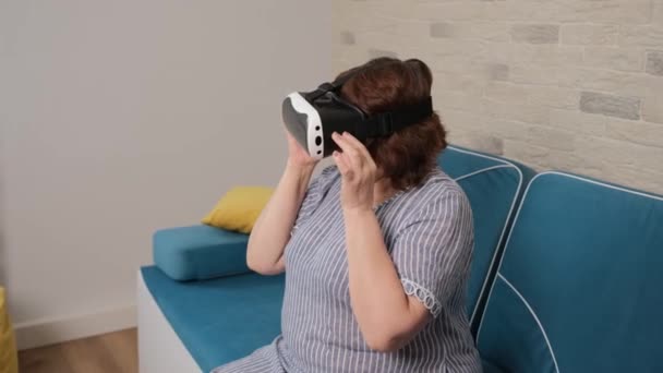 Leeftijd vrouw kijken naar een video met behulp van een virtual reality bril. — Stockvideo