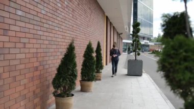 Arkasında gitar olan beyaz bir genç adam tıbbi bir maske takıyor..