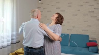 Kafkasyalı yaşlı çift oturma odalarında dans ediyor. Anın tadını çıkar..