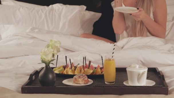 Colazione romantica a letto, primo piano di un vassoio con frutta, succo di frutta e una tazza di caffè — Video Stock