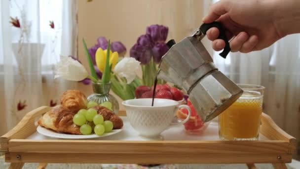Close up de uma bandeja de madeira com café da manhã, homem despeje café em copos. — Vídeo de Stock