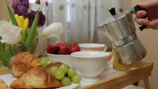 Närbild av en trä bricka med frukost, man hälla kaffe i koppar. — Stockvideo