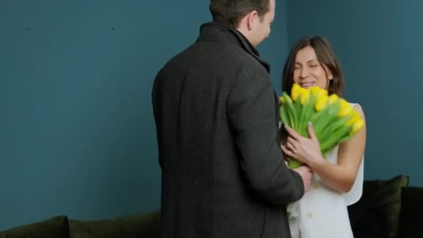 Young man came home and offered his wife a bouquet of yellow tulips. — Stock Video