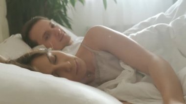 Genç ve sevgi dolu bir çift sabah uyanır. Adam yatakta karısını öpüyor ve sarılıyor..