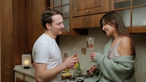 Romantikus pár, hogy élvezi egy pohár bor és pihentető a konyhában. — Stock videók