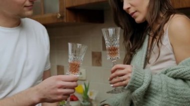 Bir bardak şaraptan ve mutfakta dinlenmekten hoşlanan romantik bir çift..