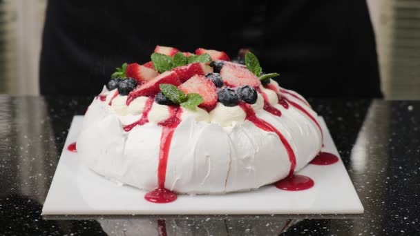 El chef de pastelería espolvorea azúcar en polvo en la torta Anna Pavlovas. — Vídeos de Stock